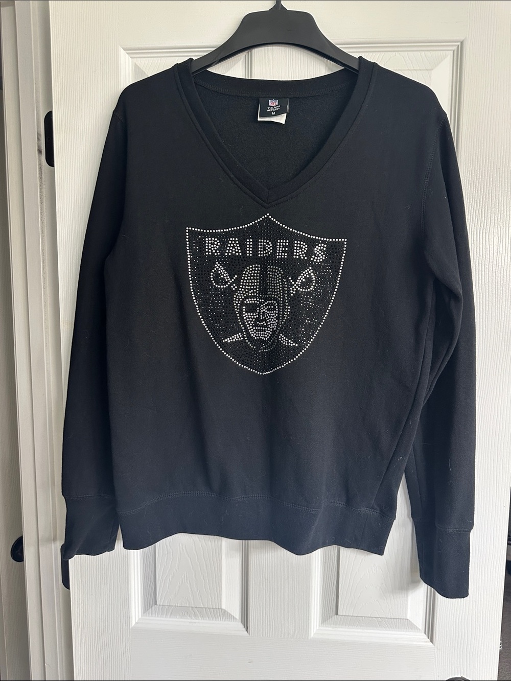 Women’s medium Raiders sweatshirt with rhinestone embellishment.